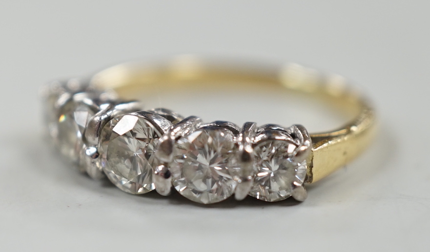 A gold and graduated five stone diamond set half hoop ring, size G/H, gross weight 2.7 grams.